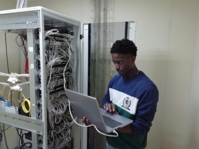 a man with a laptop fixing a server