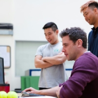 three IT guys in front of a screen